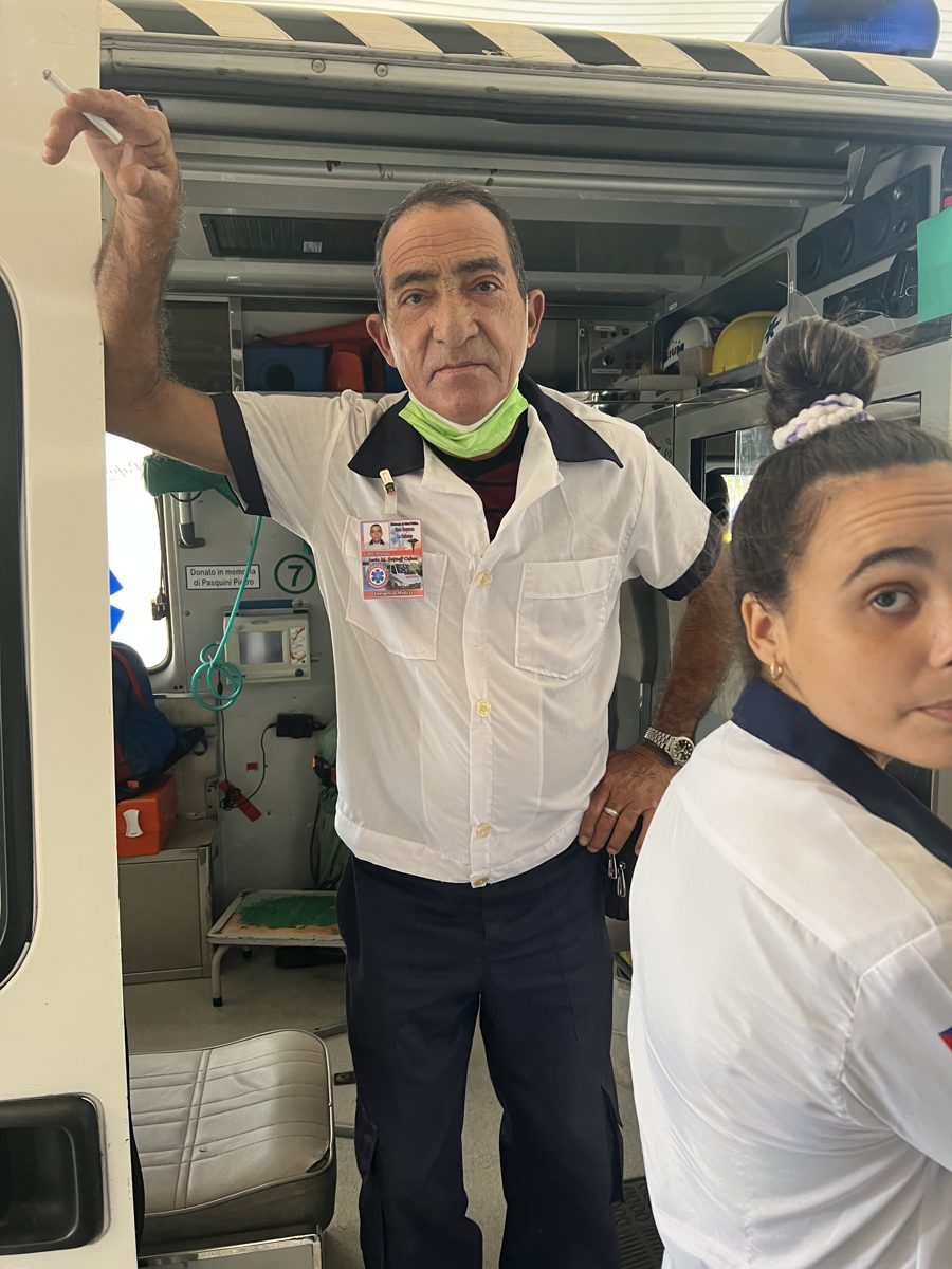 Un equipo médico de emergencias de pie junto a las puertas abiertas de su ambulancia.