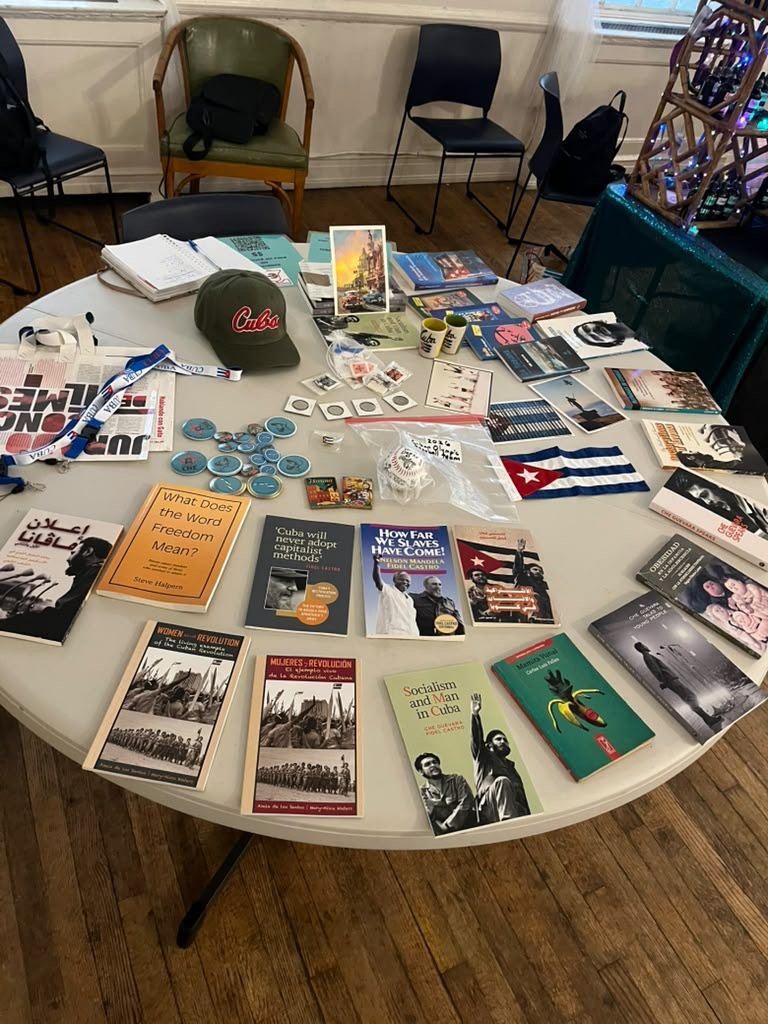 A table of books, buttons and flags about Cuba at a P4C event.