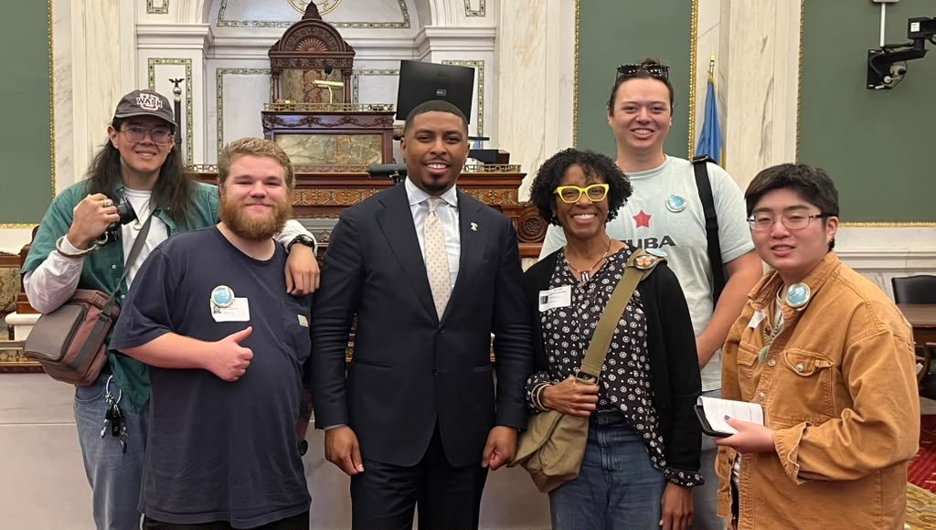 P4C members gather with a city official in an ornate hall.