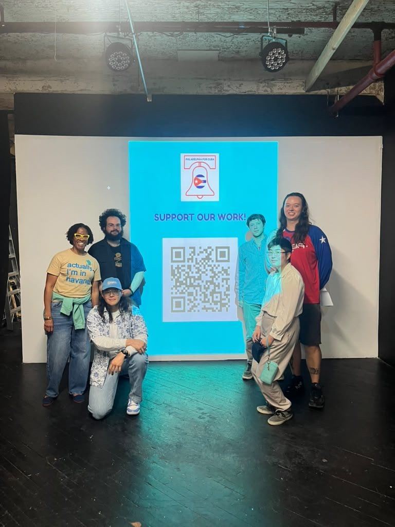 P4C volunteers stand in front of a Philadelphia for Cuba “Support our work” banner.