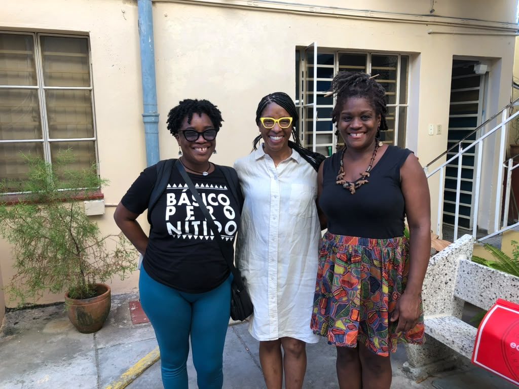 Dr. Quarterman with two women in a courtyard in Cuba.
